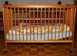 a wooden crib with a mattress in a room at Ferienwohnung bei Stadthagen mit Wlan und Waschmaschine in Niedernwöhren