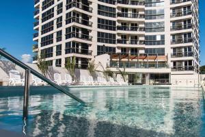 アスンシオンにある706 - The Tower Luxury 2 Bedroomの大きな建物を背景に建つスイミングプール +10枚の写真