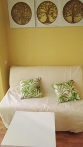 a white couch with two pillows and a table at Sueña Paco in Torremolinos
