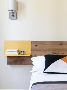 a bedroom with a bed with a wooden headboard at Hotel Ca' Mura in Bardolino