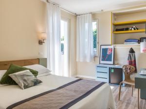 a bedroom with a bed and a desk with a television at Hotel Ca' Mura in Bardolino
