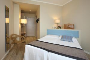 a bedroom with a large bed with a blue headboard at Hotel Ca' Mura in Bardolino