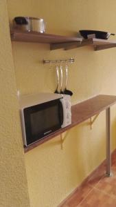 a microwave on a shelf in a kitchen at Sueña Paco in Torremolinos