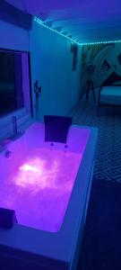 een kamer met een roze verlichte badkuip in een kamer bij studio pop art in Saint-Philbert-sur-Risle