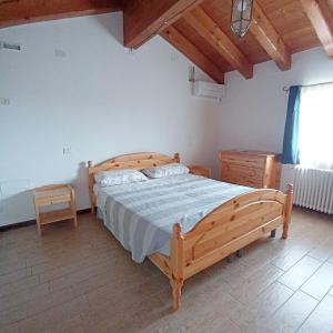 ein Schlafzimmer mit einem Holzbett in einem Zimmer in der Unterkunft Agriturismo Trabucco in Casale sul Sile