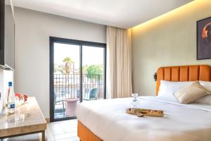 a hotel room with a bed and a balcony at Hotel Shoshana - Adults Only in Eilat