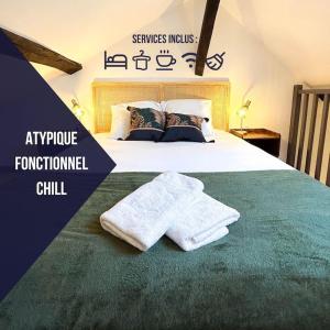 een slaapkamer met een bed met handdoeken erop bij AlloLola • Cœur de ville • Authentique & Chill in Châteauroux