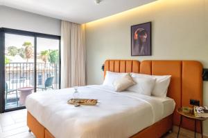 a hotel room with a large bed and a balcony at Hotel Shoshana - Adults Only in Eilat