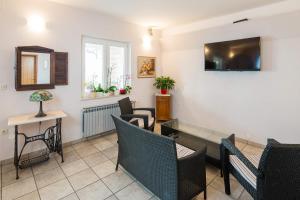 a waiting room with chairs and a table and a tv at Pansion Marjan in Zavala