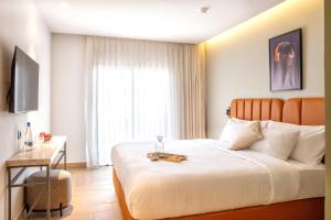 a hotel room with a large bed and a desk at Hotel Shoshana - Adults Only in Eilat