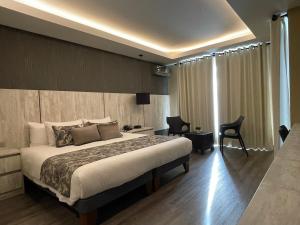 Hotel Catena في كوتشابامبا: غرفة الفندق بسرير ومكتب وكرسي