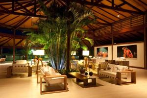 una sala de estar con sofás y una palmera en HOTEL DOM PEDRO LAGUNA, en Aquiraz