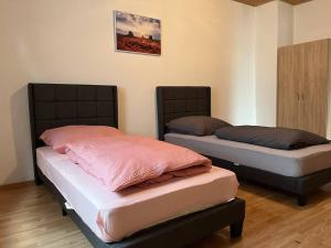 two beds sitting next to each other in a room at Gemütliche Wohnung in ruhiger Lage in Karlsruhe