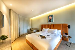 a hotel room with a large bed and a chair at Hotel Shoshana - Adults Only in Eilat