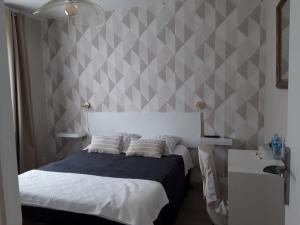 Dormitorio con cama y pared gris y blanca en Chez Zabou en Amboise