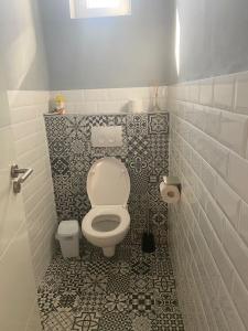 a bathroom with a toilet and a tiled floor at Sárdoár Vendégház in Abádszalók +6 photos