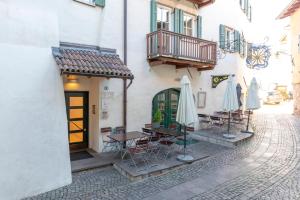 un patio avec des tables et des parasols à l'extérieur d'un bâtiment dans l'établissement Apartment Perwanger, à Appiano sulla Strada del Vino