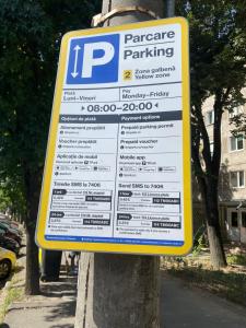 una señal de estacionamiento en un poste en una calle en SMP Apartment, en Timisoara