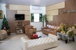 a living room with a couch and a christmas tree at Inácios Hotel ltda in Redenção