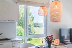 a kitchen with a window and two pendant lights at Weiße Villen "das Meeresloft" in Boltenhagen