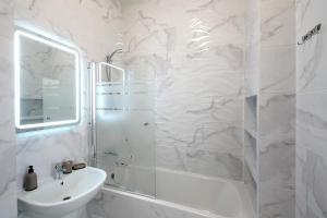 a white bathroom with a shower and a sink at Best view apartments in Lviv