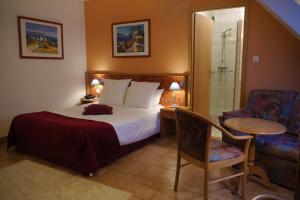 a hotel room with a bed and a table and chair at Hôtel sud alsace in Ranspach-le-Bas