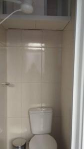 a white bathroom with a toilet in a room at Aconchegante apt c/ garagem in Serra Negra