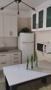 uma cozinha com um balcão branco e um micro-ondas em Aconchegante apt c/ garagem em Serra Negra