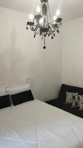 a bedroom with a chandelier hanging over a bed at Aconchegante apt c/ garagem in Serra Negra