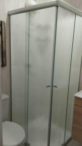 uma cabina de duche em vidro numa casa de banho com WC em Aconchegante apt c/ garagem em Serra Negra