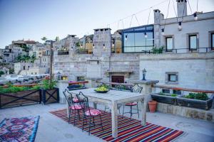 a patio with a table and chairs on a balcony at Petra Inn Cappadocia in Uchisar