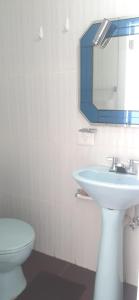 uma casa de banho com um lavatório, um WC e um espelho. em MI ESTANCIA HOSPEDAJE em Cuenca