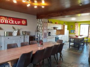 une salle à manger avec une grande table et des chaises en bois dans l'établissement Gite 1 de Renuamont, à Sainte-Ode