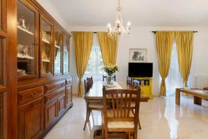 a dining room with a dining table and yellow curtains at Ca' Lina in Licciana Nardi