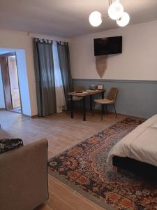 - une chambre avec un lit, une table et une télévision dans l'établissement Iosif 55, à Sighişoara