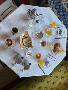 a table with breakfast foods on a white table cloth at Dar Fadma in Ouarzazate
