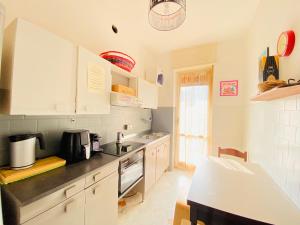a kitchen with white cabinets and a counter top at Milano relax family house in Brugherio