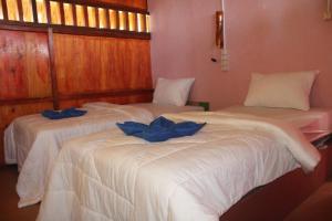 2 Betten in einem Zimmer mit blauen Bogen in der Unterkunft NGGELA Beach Bungalows in Basa