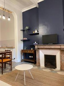 a living room with a fireplace and a table at La Grande Dame - T4 - Clim in Perpignan