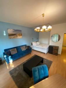 ein Wohnzimmer mit einem blauen Sofa und einem Bett in der Unterkunft apartment with balcony in Berlin