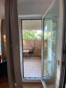 eine Glastür, die auf eine Terrasse mit einem Tisch führt in der Unterkunft apartment with balcony in Berlin