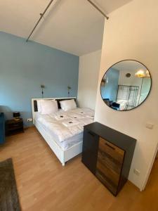 a bedroom with a bed with a mirror on the wall at apartment with balcony in Berlin
