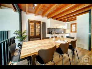 uma cozinha e sala de jantar com uma mesa de madeira e cadeiras em CASA DEL VALLE de Alma de Nieve em Tredós