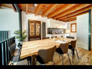a kitchen and dining room with a wooden table and chairs at CASA DEL VALLE de Alma de Nieve in Tredós