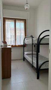 福薩切西亞的住宿－All'altezza del mare，客房设有两张双层床和一扇窗户。