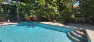 ein Schwimmbad in der Mitte eines Gartens in der Unterkunft Maison Avec Piscine, Tennis, Sauna in Marsillargues