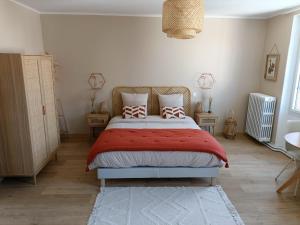 um quarto com uma cama com lençóis e almofadas vermelhas em Chez Lucy&Nico em Verfeil