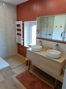 ein Badezimmer mit zwei Waschbecken und einem großen Spiegel in der Unterkunft Chez Lucy&Nico in Verfeil