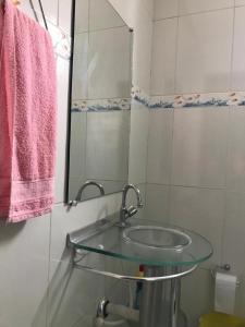 ein Badezimmer mit einem Glaswaschbecken und einem Spiegel in der Unterkunft Casa aconchego in Canindé de São Francisco