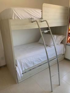 a couple of bunk beds in a room at Apartamento na Praia do Saco - Condomínio Villa das Águas in Estância